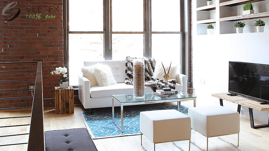 Faux fur toss pillows and a faux fur throw add a modern edge to the loft in this urban living room